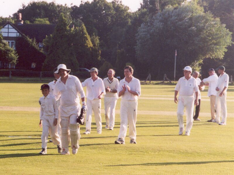 The end of another sunny Saturday afternoon's cricket in idyllic surroundings. Badgers leave the field after defeating Ewhurst, July 2000